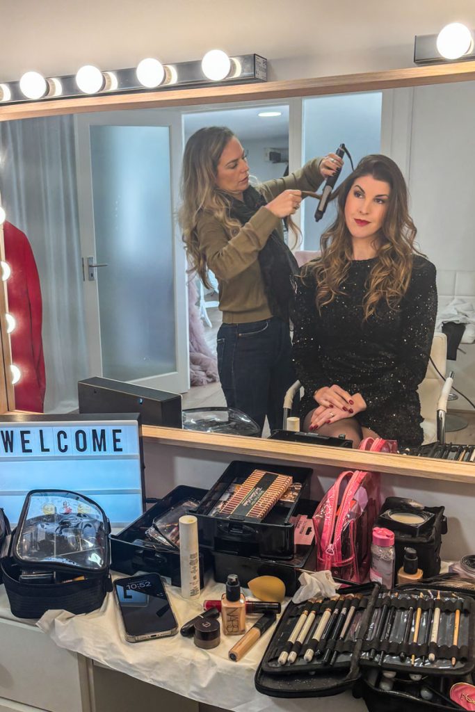 Woman having professional hair and makeup at a luxury portrait photoshoot looking relaxed and confident