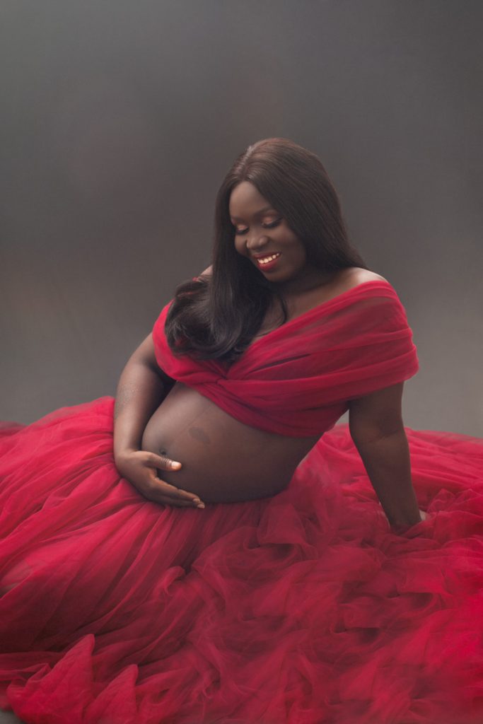 Expecting mother holding her bump during a motherhood portrait session at Wani Olatunde Photography Milton Keynes